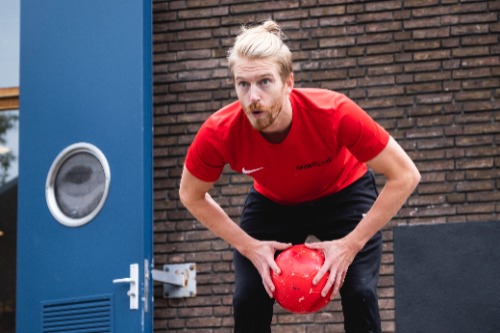 Anne Bakker in een sportpositie met een bal